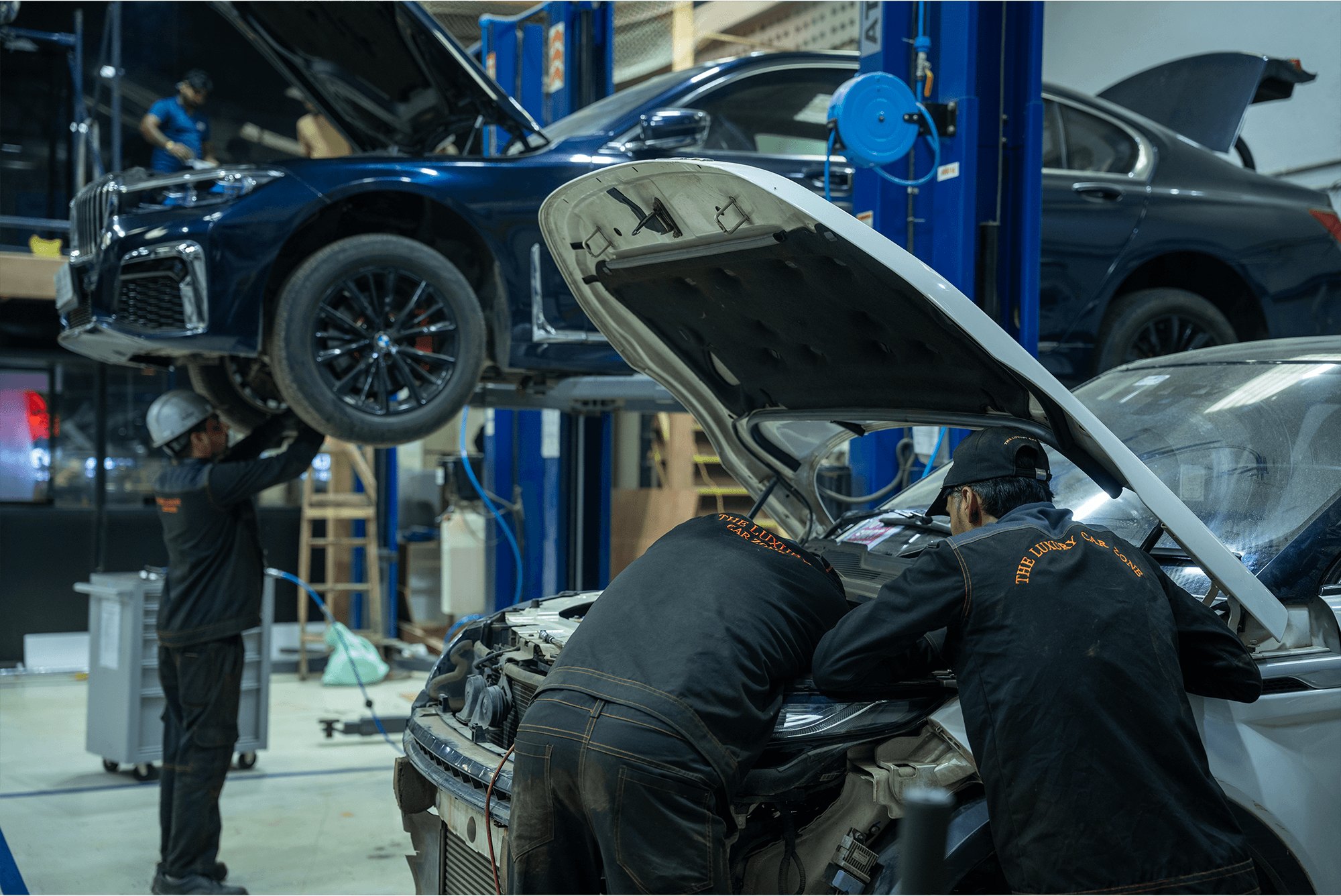 A technician working deep in an open engine bay